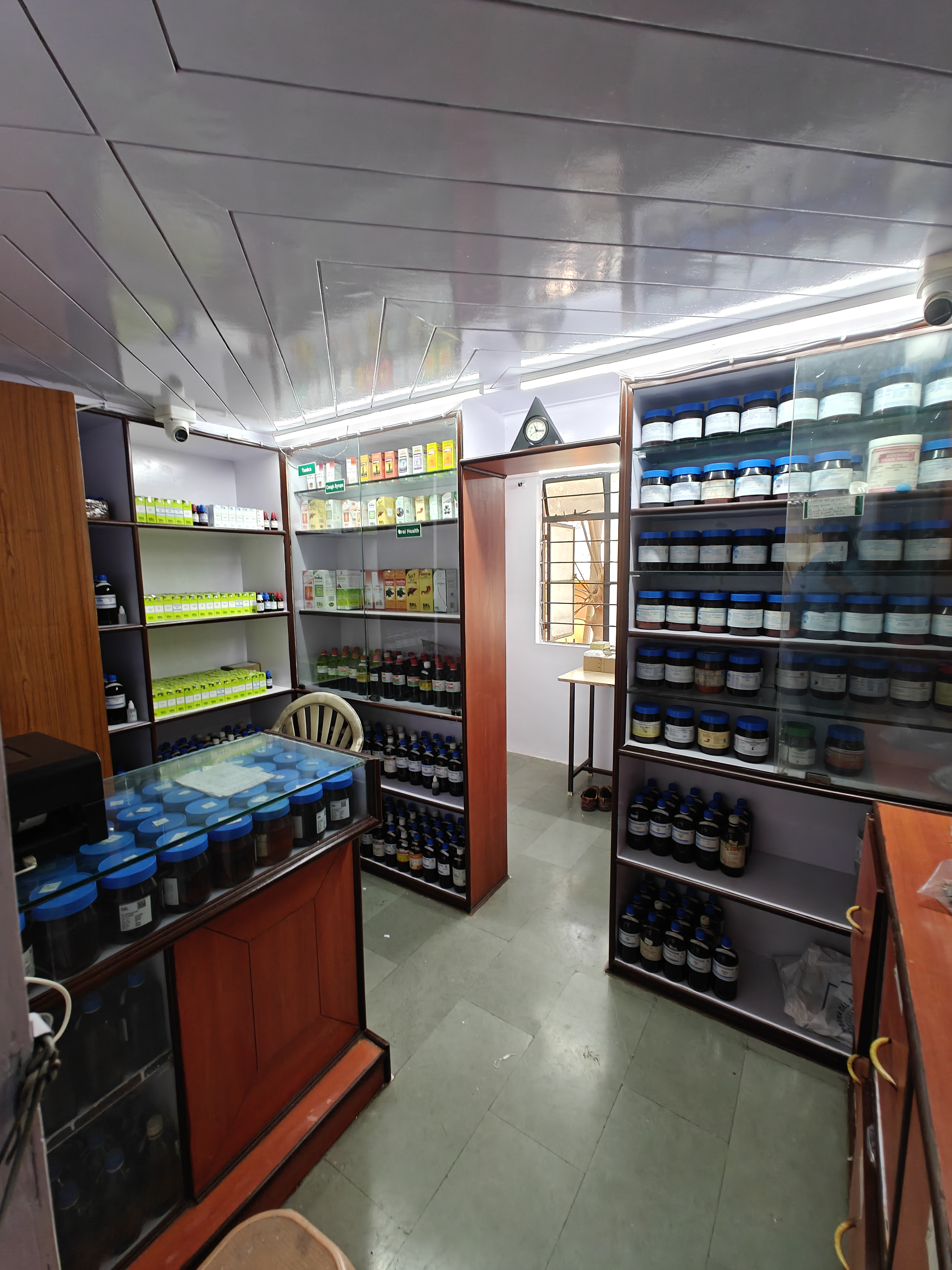 Shree Homoeo Pharmacy interior — well-stocked shelves of homoeopathic medicines